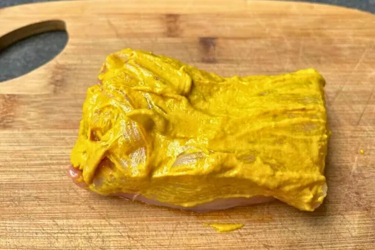 Why put mustard on chicken before grilling